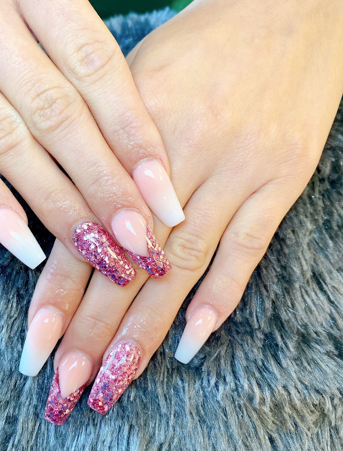 Lange acrylnagels, naturel naar wit, met twee nagels in roze glitter