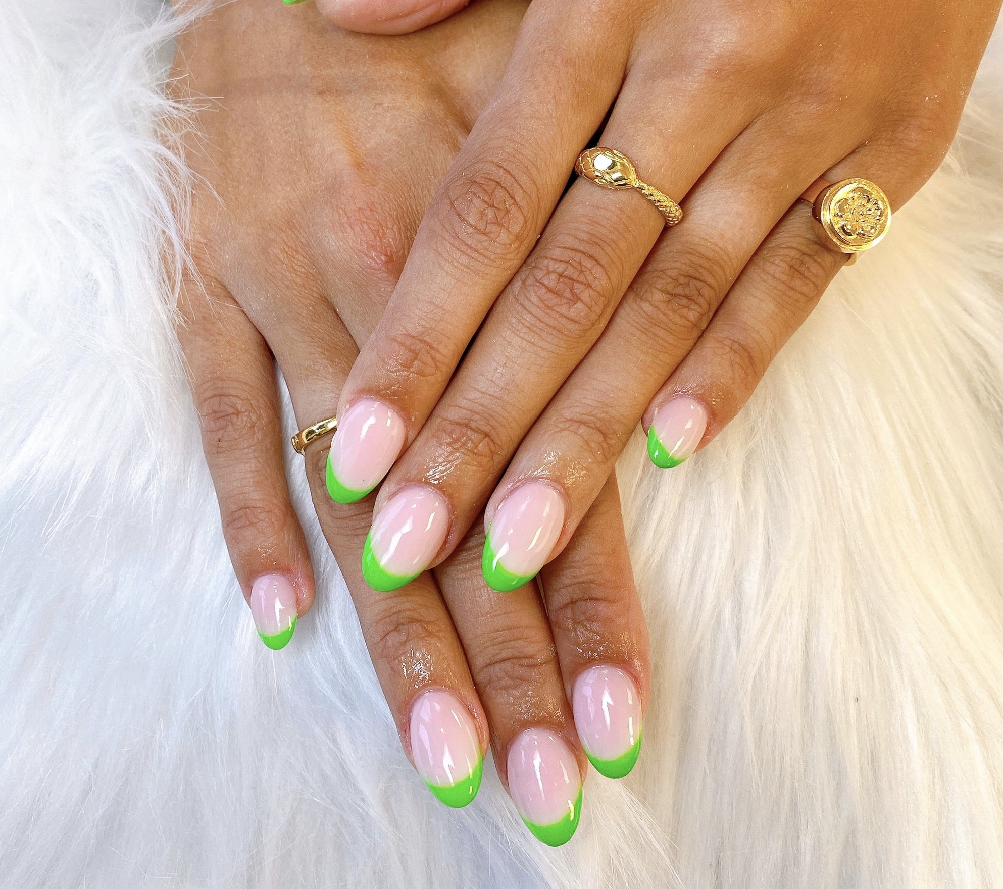 Naturel nagels met groene french tips, op een witte vacht
